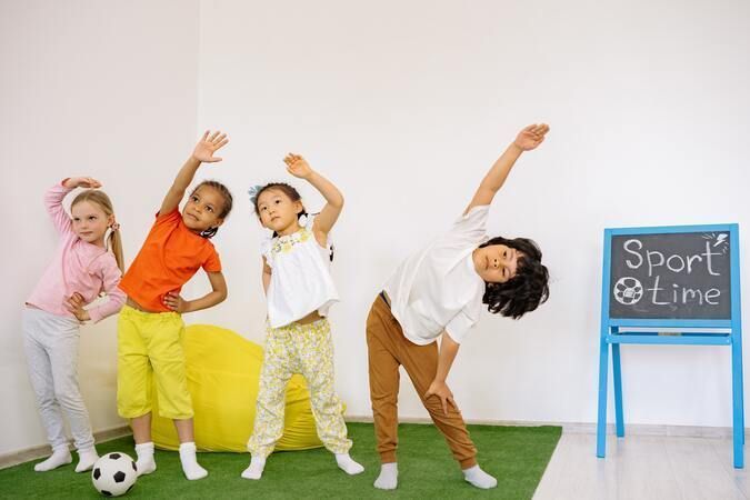 Niños pequeños haciendo ejercicio en clase.